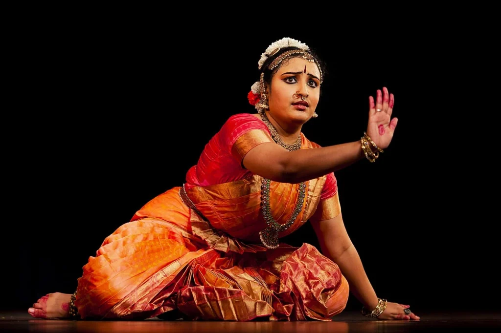 Bharatanatyam dancer performing on stage in traditional costume