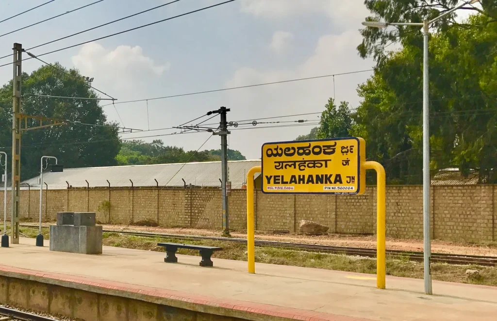 Yelahanka railway station board showing Kannada, Hindi and English names on a platform sign