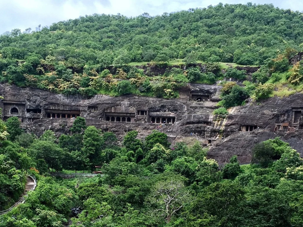 Green hillside with rock-cut Ajanta caves in Maharashtra after the monsoon