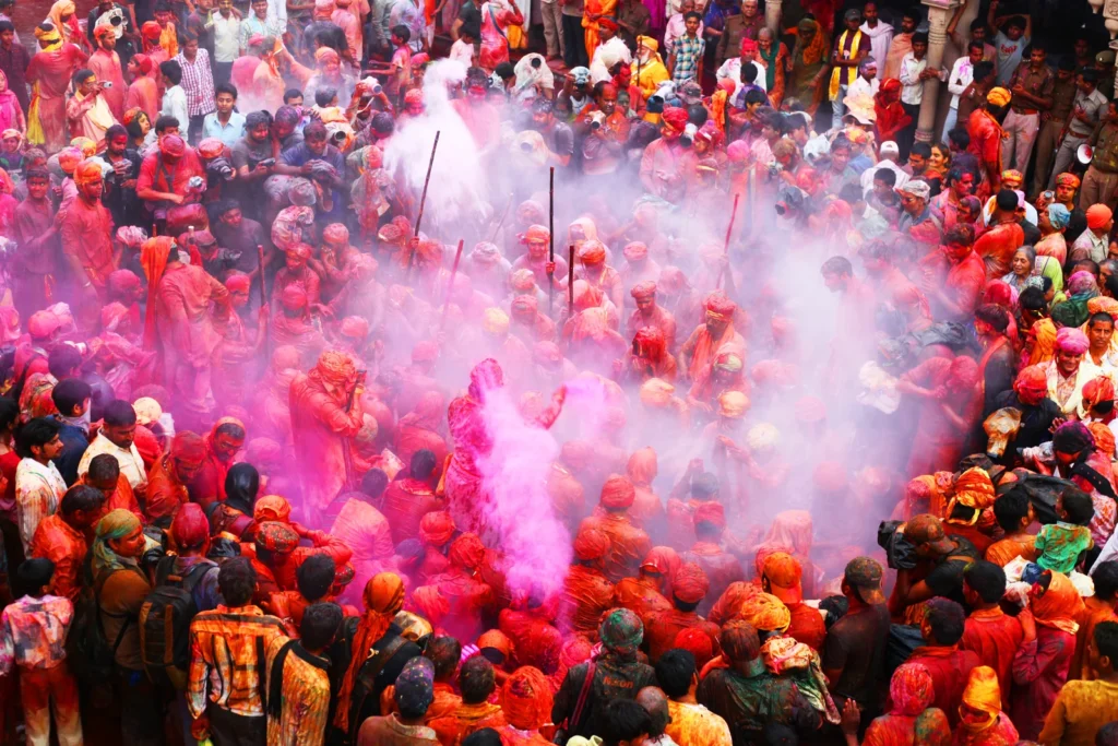 Crowd of devotees celebrating Holi inside a temple in Nandgaon near Barsana