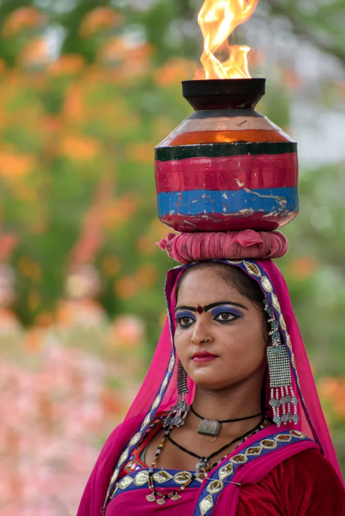 Rajasthani folk dance performer wearing traditional dress and balancing a decorated pot with flame