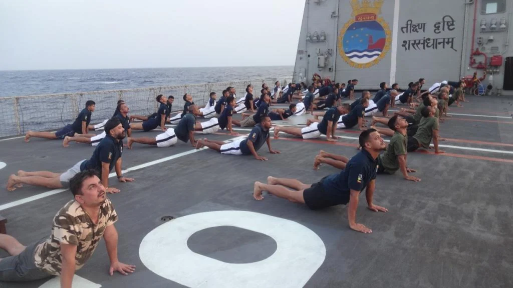 Indian Navy personnel practising Bhujangasana together on board INS Sunayna