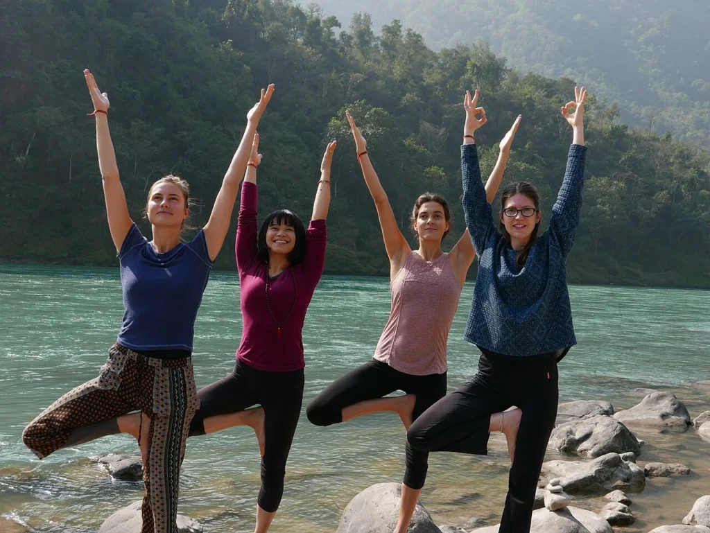 Group of people performing balancing yoga posture outdoors near Rishikesh