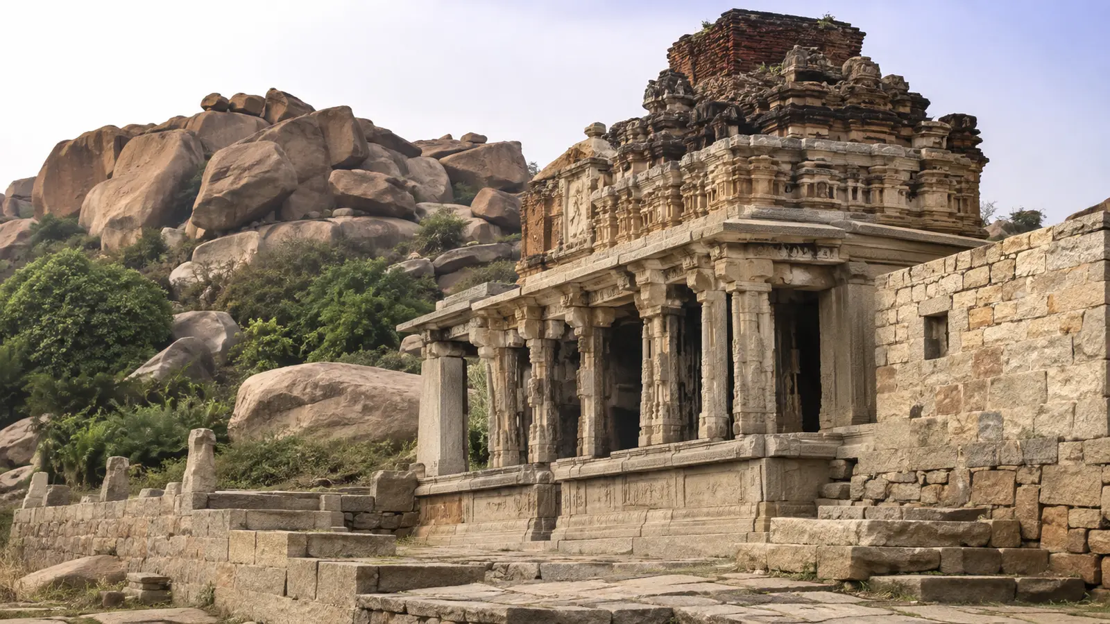 Weathered stone architecture set among granite boulders in the Deccan region.